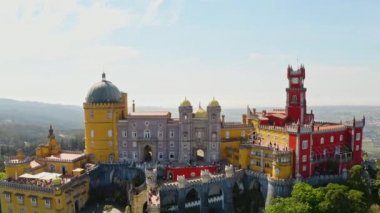High aerial view Pena palace portuguese heritage of unesco stronghold historic european residence catholic fortress with yellow red decorative facade mansion on summit rocky hilltop in Sintra Portugal