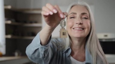 Gray-haired female buyer homeowner broker caucasian woman old granny seller holds bunch keys of rental apartment flat leases lodging room new dwelling win home accommodation modern housing improvement