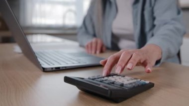 Close up female wrinkled hands of unknown mature woman housewife calculate numbers on calculator counting financial papers documents planning budget utilities bills loan payment managing bank finances