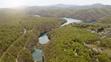 Aerial top view from above on Plitvice Lakes, natural attraction waterfalls river and caves Croatia surrounded by mountain slopes and coniferous green forest. Beautiful perfect place to travel trip