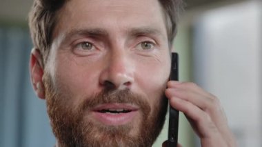 Closeup smiling Caucasian adult 40s bearded man talking mobile phone in office. Headshot cheerful businessman talk speaking telephone call answer calling consulting client remote conversation portrait