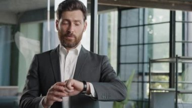 Portrait angry worried bearded 40s Caucasian businessman male frustrated boss manager waiting meeting in office nervous shake head with annoyance frustrated pointing finger on wrist watch late time
