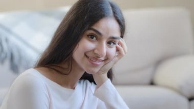 Beautiful sexy young hispanic arabian turkey woman girl tidy attractive lady with dark seductive eyes natural daily makeup resting at home relaxing looking at camera holding head on palm posing indoor