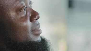 Close up portrait male face dreamful african adult man bearded inspirited american businessman with dark skin look at distance deep in thoughts think difficult decision generate ideas imagine future