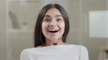 Emotional surprised female face arabic 20s young girlfriend millennial pretty ethnic woman student freelancer demonstrate positive wow reaction euphoria feel delight shock enjoyment successful triumph