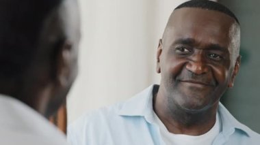 Mirror reflection male figure handsome senior african american middle aged confident man unshaved joyful grandfather businessman posing in dressing room at home laughing wink to himself planning date