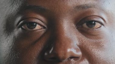 Extreme close up african male face in detail adult man model client of ophthalmology with dark skin tired unhealthy eyesight vision problems after hard computer work opens eyes laser correction lenses