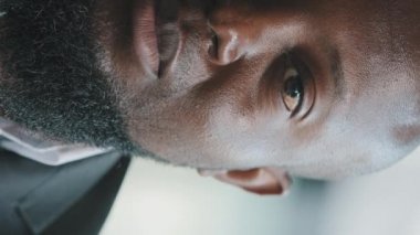 Portrait half face african american male plus size bearded groomed man ethnic millennial businessman sad adult guy serious eyesight posing indoors in formal suit looking at camera calmness expression