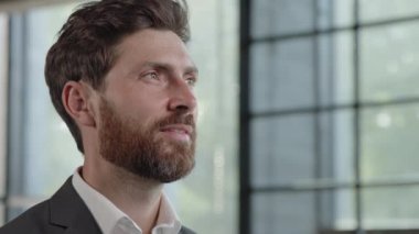 Close up successful pensive puzzled dreaming contemplating man Caucasian thoughtful adult mature 40s businessman looking out window thinking idea strategy dream brainstorming deep in thoughts smiling