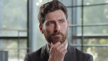 Thoughtful Caucasian bearded 40s businessman thinking solving business problem pensive male professional think in office. Focused CEO boss leader clever puzzled confused man deep in planning thought