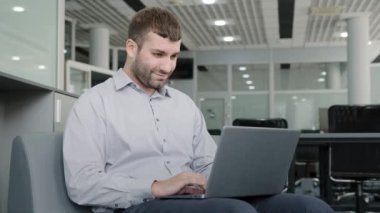 Focused confident caucasian businessman typing on laptop works in office thinks creating work plan coming up with new idea in internet serious young man checking email chatting online on social media