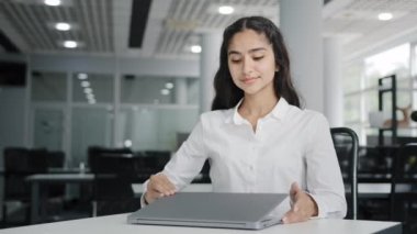 Young tired woman office worker working on laptop typing report finishes work calm balanced female manager meditates with closed eyes resting at workplace improves mental health relaxes practices yoga