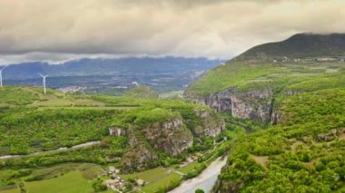 Breathtaking aerial view beautiful green landscape on slopes of mighty mountains nature scenery alpine mountains hills canyon cloudy gray sky small European village Italy lake Garda relaxing travels
