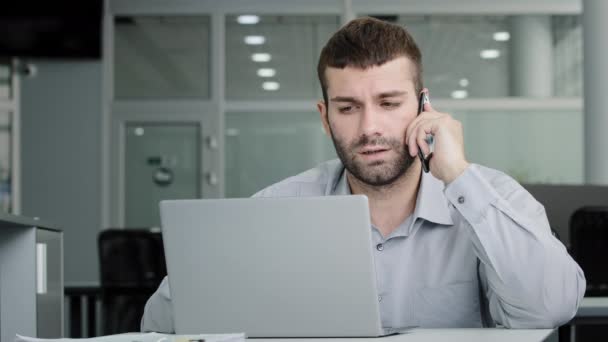 Concentrated Young Businessman Speaks Phone Consults Client Checks Data Laptop — 비디오