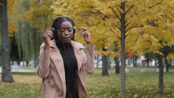 Young Funny Carefree Woman Walks Autumn Park Listens Rhythmic Music — Video