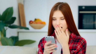Surprised joyful female winner teenage user freelancer caucasian redhead lucky girl woman browsing online clothing shop win discount in internet mobile app rejoice victory read good sms on smartphone