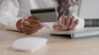 Close-up female hands unrecognizable woman enters credit card details in computer paying bill consumer pays for purchase in online store using e-bank computer application simple secure payment concept