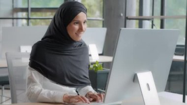 Excited joyful businesswoman sitting at workplace in office receiving email on computer reading excellent news enthusiastic happy woman manager rejoicing in victory celebrating success good result