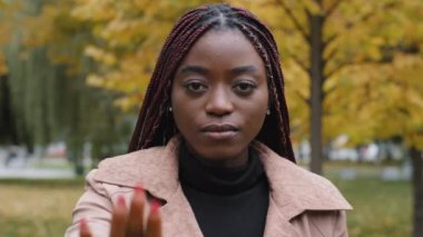 Close-up young serious focused angry african american woman holding palm in front showing stop gesture showing prohibition sign forbidden protect personal boundaries against discrimination violence