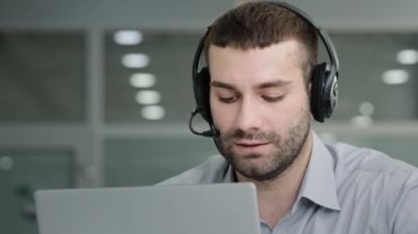 Millennial confident manager talking to employees negotiating using headset on online conference in office professional call center operator consulting client speaking to customer uses remote web chat