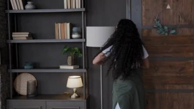 Young funny comical woman having fun dances waltz alone excited girl humorist dancing expressively hugs and kisses lamp fooling around moves energetically enjoying pleasant favorite music at home