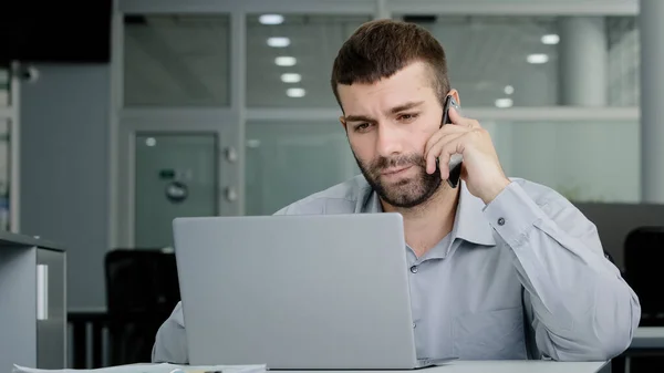 Concentrated Young Businessman Speaks Phone Consults Client Checks Data Laptop — Stockfoto