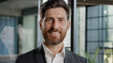 Happy smiling bearded Caucasian middle-aged business man small business owner company leader CEO male sales manager cheerful executive successful lawyer broker guy looking at camera standing in office