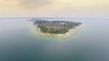 Aerial view island on Lake Garda in Italy ancient landmark in resort town Sirmione Caves Catullus ruin ancient Roman building remains formed after collapse of walls tourist destination excursion group