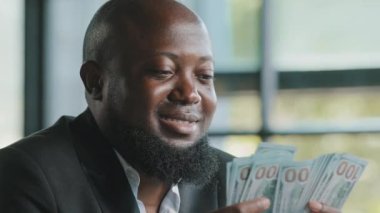 Successful african american rich businessman male investor accountant cashier counting personal earnings holding real payment salary stack money dollars win bet cash prize loan deposit monetary budget