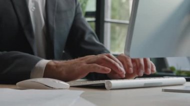 Close-up male hands of unrecognizable Caucasian businessman typing on computer modern keyboard and click working at office texting chatting online browsing programming remote job searching business