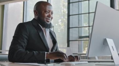 Middle aged business specialist african american man entrepreneur working on computer at office senior IT manager web designer programmer ceo agent trading online e-commerce check email data analysis
