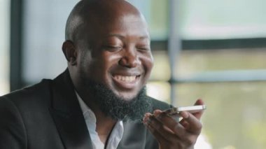 Handsome african man record voice message audio text recognition sound app in mobile smartphone digital translator use speakerphone for loud wireless chatting set reminder command virtual assistance