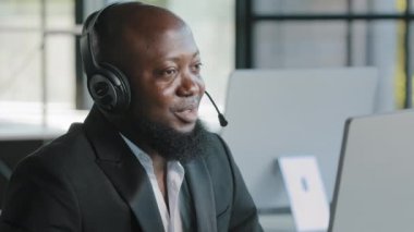 African american business person ceo consultant lawyer advisor recruiter hr manager in headphones with microphone talking at computer webcam consulting online interviewing distant negotiation remotely