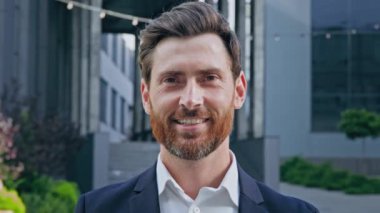 Headshot smiling positive bearded professional businessman in suit looking at camera standing on street confident successful handsome male entrepreneur manager leader posing outdoors business portrait