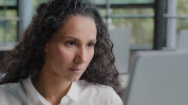 Focused serious woman working on computer in office looking at monitor close-up pensive female professional worker reading information to develop new project thinks researching plan work on Internet