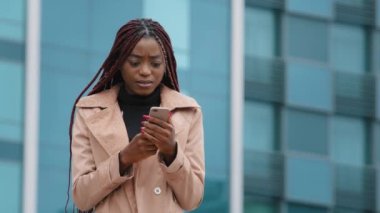 Upset shocked young woman standing outdoors receiving email on cellphone reading bad news sad distressed girl feels frustration after reads sms suffering from desperation hopelessness failure concept