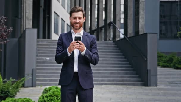 Young Successful Businessman Standing Outdoors Business Center Holds Phone Ordering — Vídeos de Stock