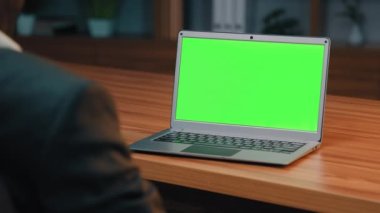 Close-up view from back busy businessman looking at green screen laptop talking on video call negotiating communicates with client at online conference via webcam holds webinar using modern technology