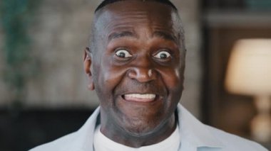 Glad happy african american grandfather ethnic man unshaved elderly 60s retired confident businessman handsome mature gentlemen laughing smiling white toothy smile gaze looking at camera posing indoor