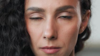 Close up headshot female portrait indoors 30s sad upset arabian girl with good face skin natural daily make-up raise serious frustrated eyesight looking at camera blinking victim of bulling violence