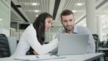 Young recruit woman presenting project on laptop to mentor professional female manager training new male worker explains online services to client on monitor discussing teamwork at business meeting