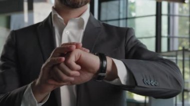 Moving footage shot male professional specialist fashionable businessman bearded Caucasian adult man looking at luxury trendy wristwatch checking time minutes to date job interview smile toothy happy