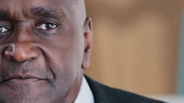 Front view horizontal moving footage sad serious calm old senior elderly African American businessman 60s male man with eyesight problem upset elder boss looking at camera indoor closeup wrinkled face