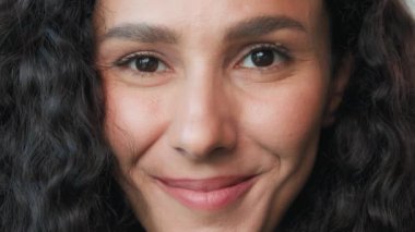 Close up girl face young beautiful arabian hispanic mexican model young woman gorgeous lady with curly hairstyle open eyes positive smiling looking at camera cheerful soft white healthy smile laughing