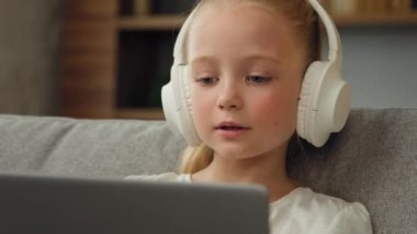 Sarışın, güzel bir çocuk kulaklıkla melodi dinliyor favori modaya uygun pop müzik beyaz kız şarkı söylüyor dizüstü bilgisayardan müzik çalıyor internetten canlı müzik izliyorlar