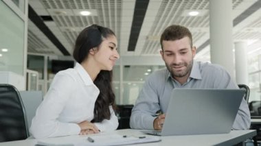 Woman manager consulting male client explaining benefits offer on laptop female sales agent showing online presentation teaching trainee conclude investment agreement shake hands making business deal