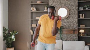 Sportive active male african sportsman healthy masculine senior fit man in good physical shape training at home workout exercises pumping biceps with dumbbells flexing practice sport body care concept