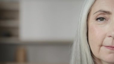 Close up human half face mature caucasian woman calm grey-haired elderly wise granny attractive senior 60s female pensioner grandmother patient of cosmetology medicine service stare looking at camera