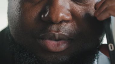 Close up view of unrecognizable african american male businessman bearded thick man reporter journalist talk mobile phone distant negotiation interview client remotely at office wireless communication