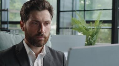 Close up caucasian bearded middle aged 40s freelancer man worker user manager company CEO employee businessman working on computer concentrated entrepreneur developing new project online on laptop app